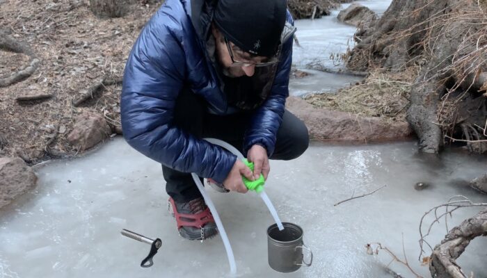 瑞恩用吸管从结冰的小溪中抽水