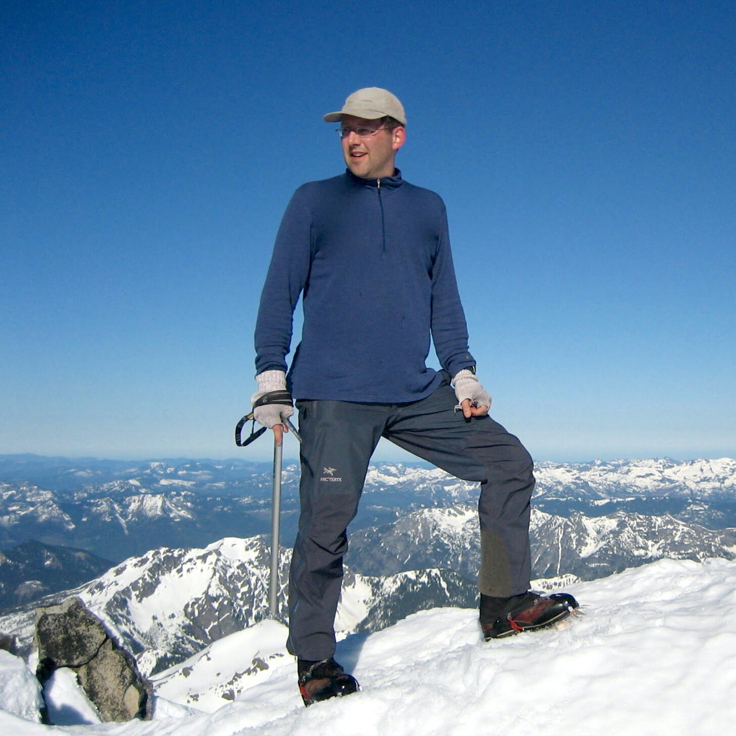 一个男人站在以群山为背景的山峰上。