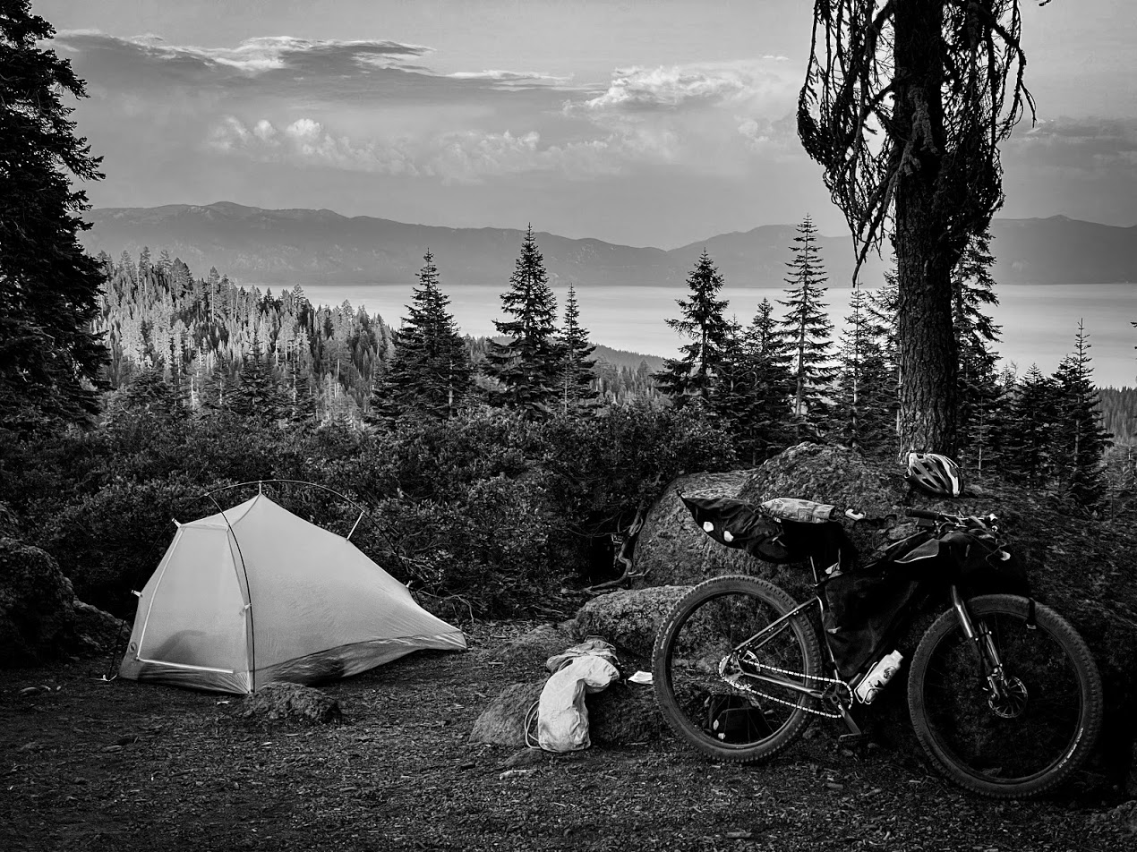 在高山湖的山脊上，一辆自行车和一个帐篷的黑白图像。