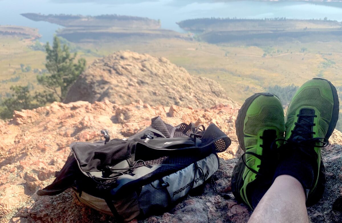 徒步旅行者穿着越野跑鞋，背着背包，在山上观看风景