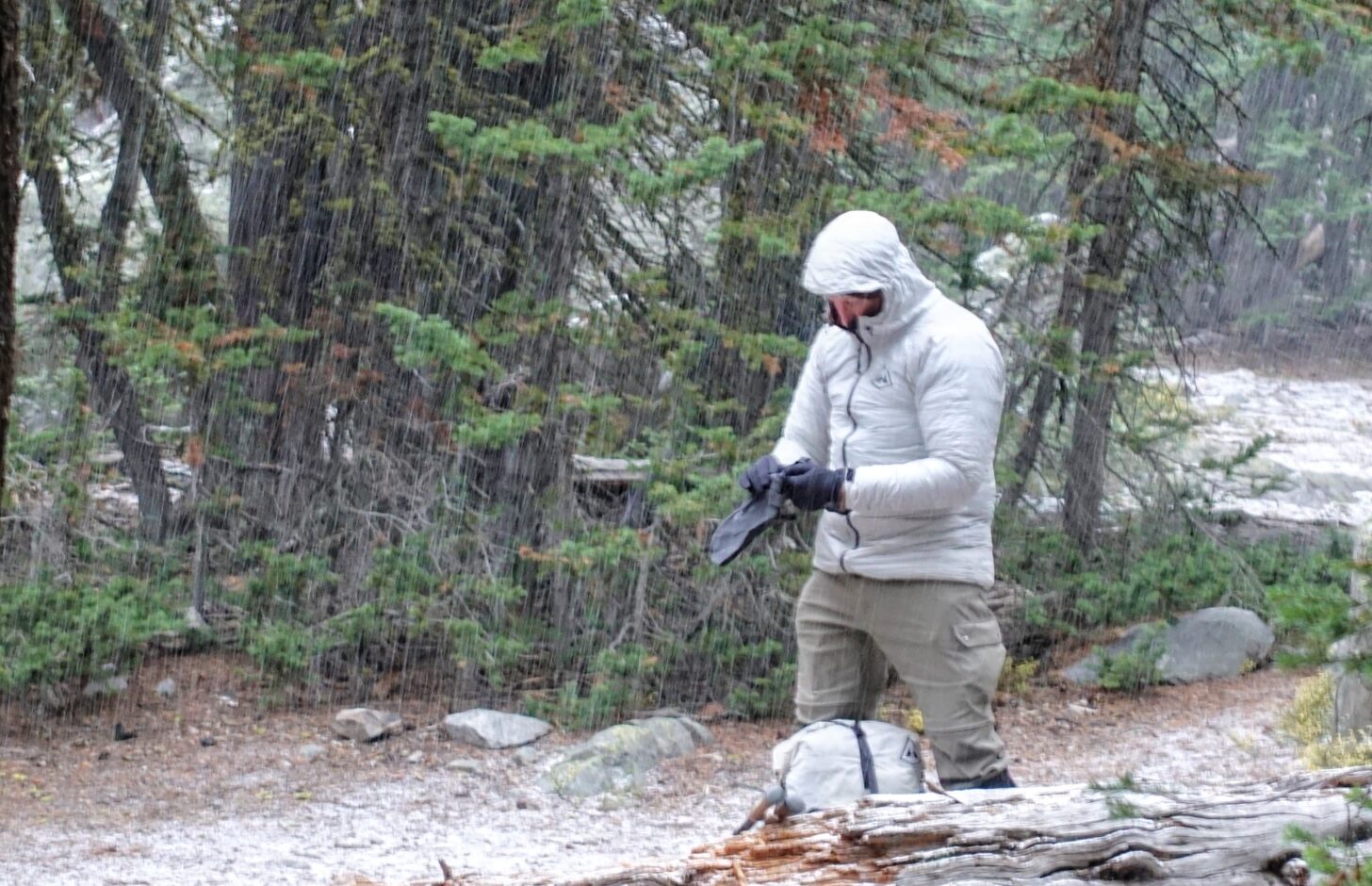 男子在下雪天在森林里徒步时戴上了连指手套